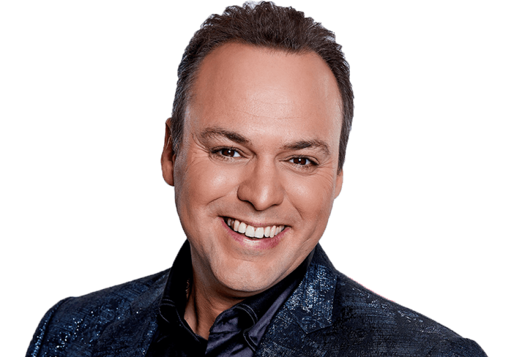 Frans Bauer zingt live op het podium tijdens een optreden vol meezingers, levensliederen en een lachend, dansend publiek