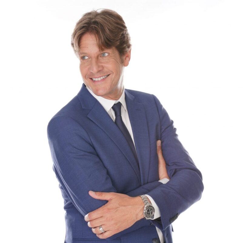 Gunther Neefs zingt live op het podium met warme stem en stijlvolle performance tijdens een sfeervol evenement