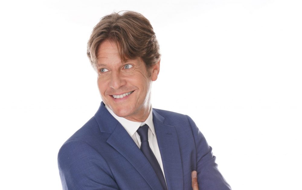 Gunther Neefs zingt live op het podium met warme stem en stijlvolle performance tijdens een sfeervol evenement