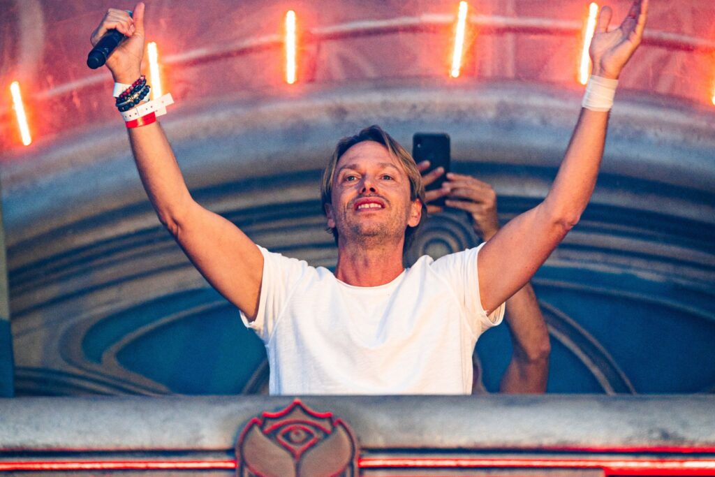 Regi live op het podium tijdens een spectaculaire show met visuals, beats, publiek en gastzangers