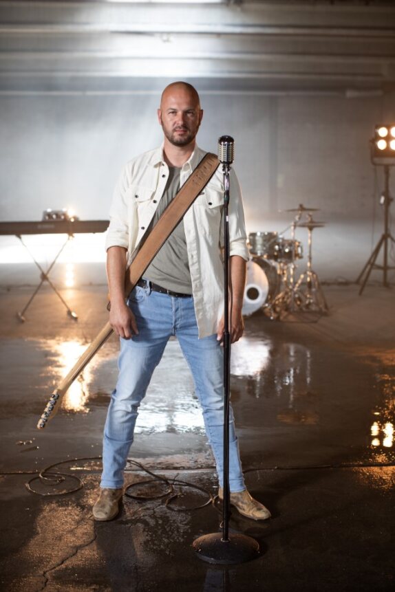 Stan Van Samang live zingend op het podium met band en publiek, sfeervolle verlichting en oprechte emotie