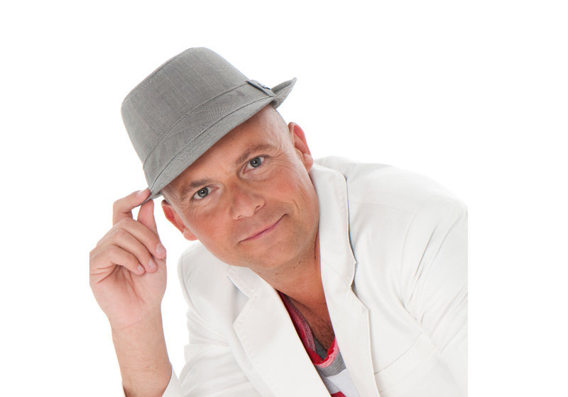 Wim Leys live op het podium, zingend en in interactie met dansend publiek tijdens een swingend optreden