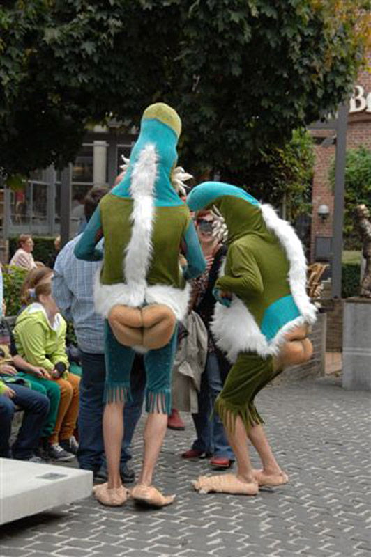Straatanimatie Bababoons in kleurrijke kostuums tussen lachende mensen op een evenement