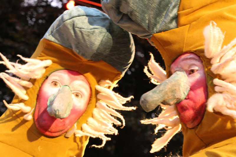 Straatanimatie Bababoons in kleurrijke kostuums tussen lachende mensen op een evenement