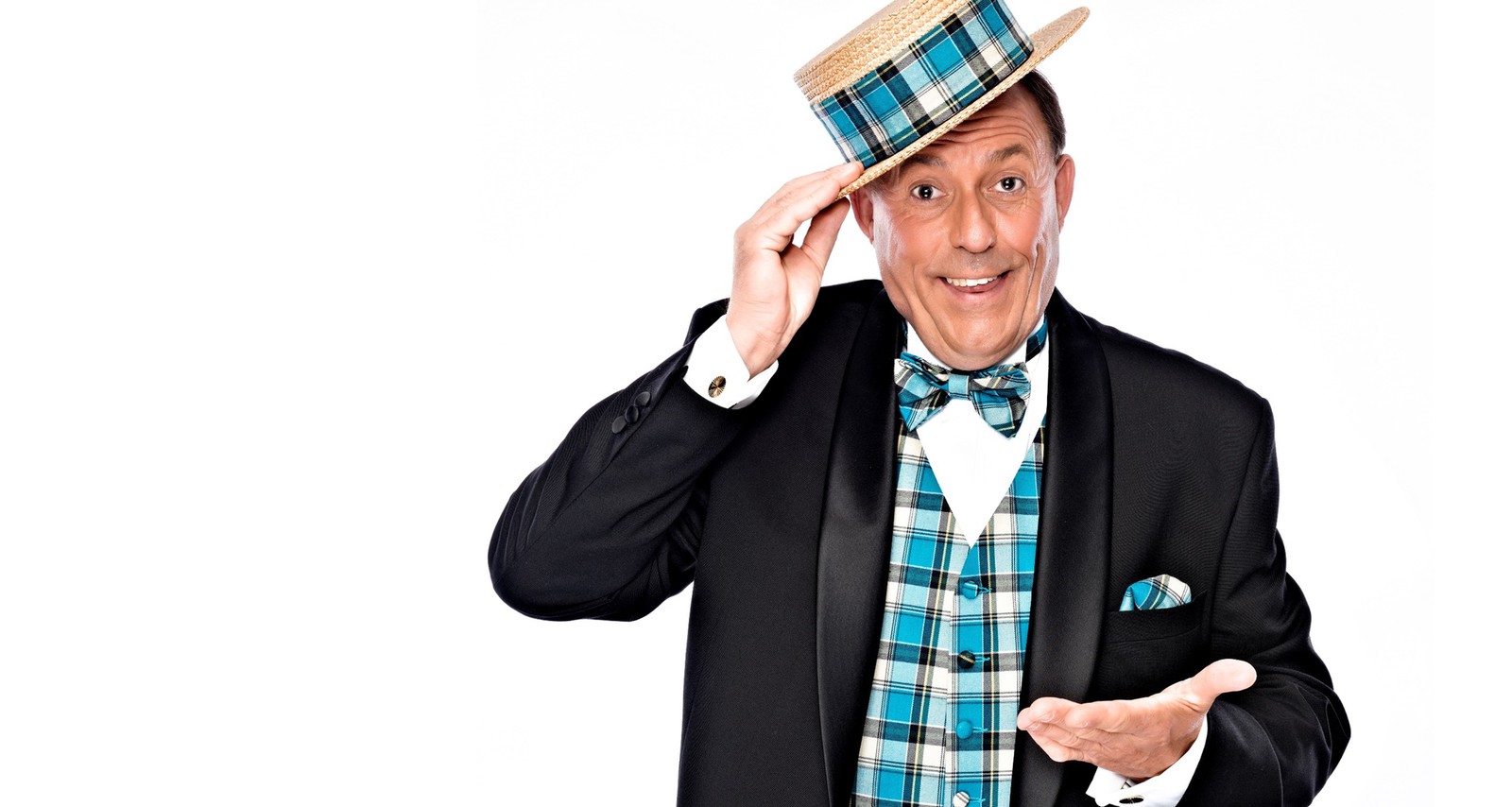 Eddy Herman op podium als presentator tijdens seniorenshow met microfoon en glimlach