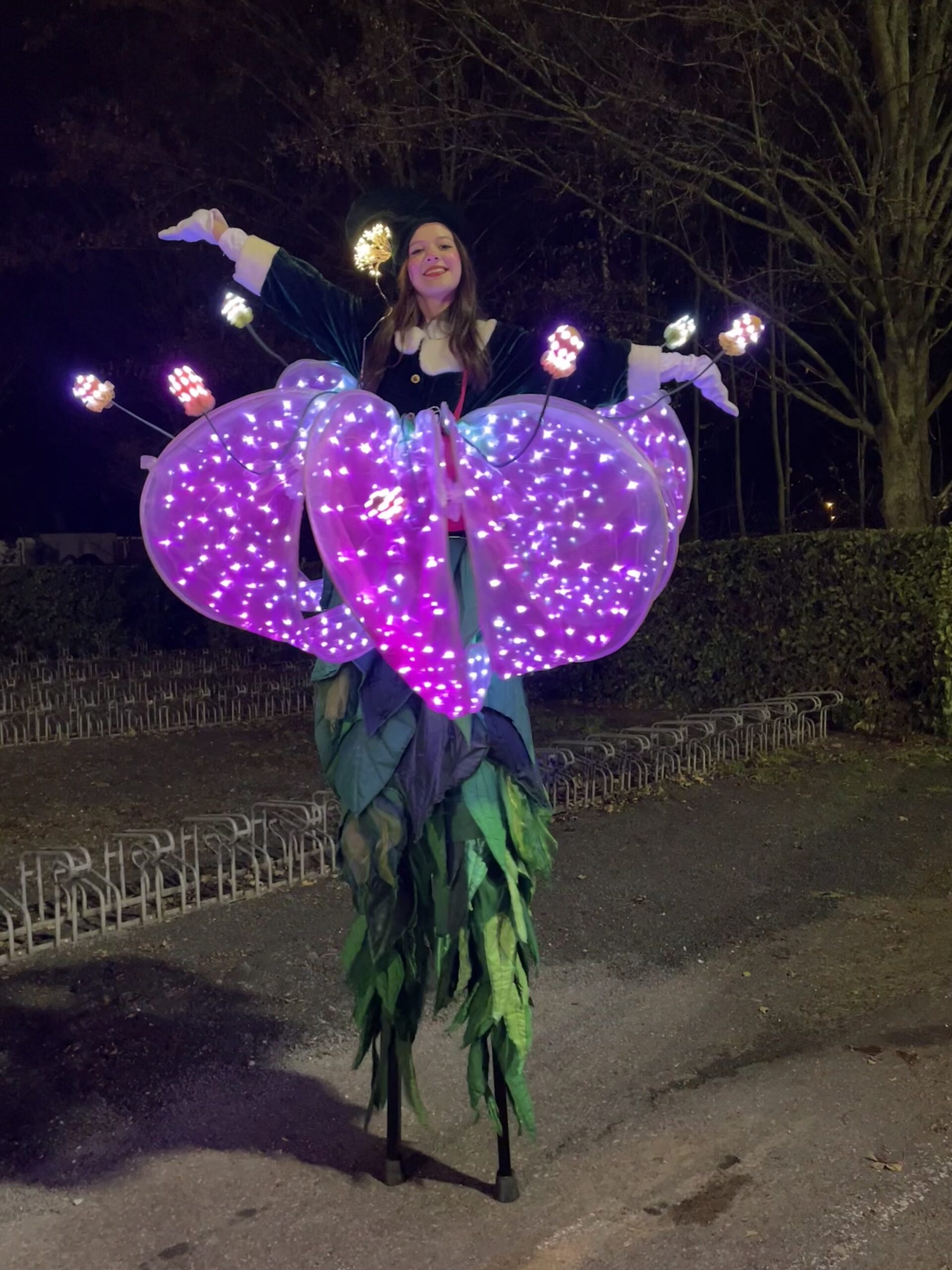 Twee steltlopers verkleed als kleurrijke bloemen tijdens een straatevenement