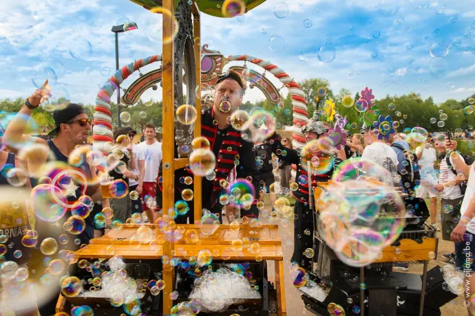 Straatartiest combineert vuurshow en bellenkunst tijdens betoverende animatie op een avondfestival