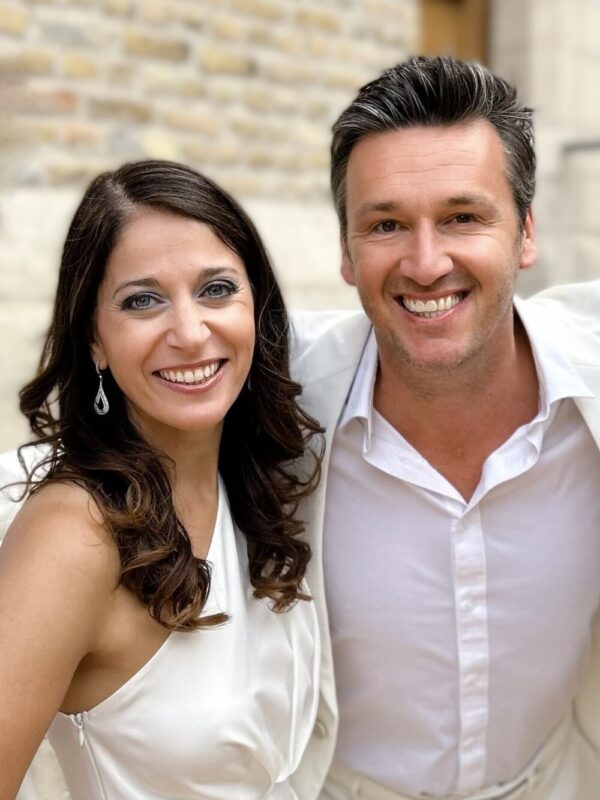 Sasha & Davy zingen live op podium in harmonie met warme belichting en enthousiast publiek