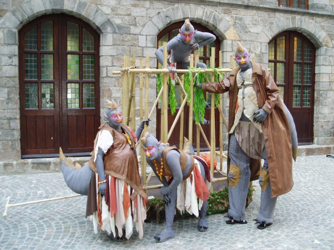 Steltloper in dino-kostuum met acrobatisch kind in kooi tijdens straatanimatie