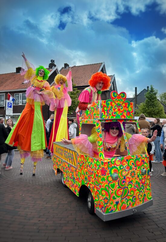Mobiele disco-act met DJ, steltenlopers en dansers in seventies outfit – rollende disco kar met lichten op festival via Dream Animations