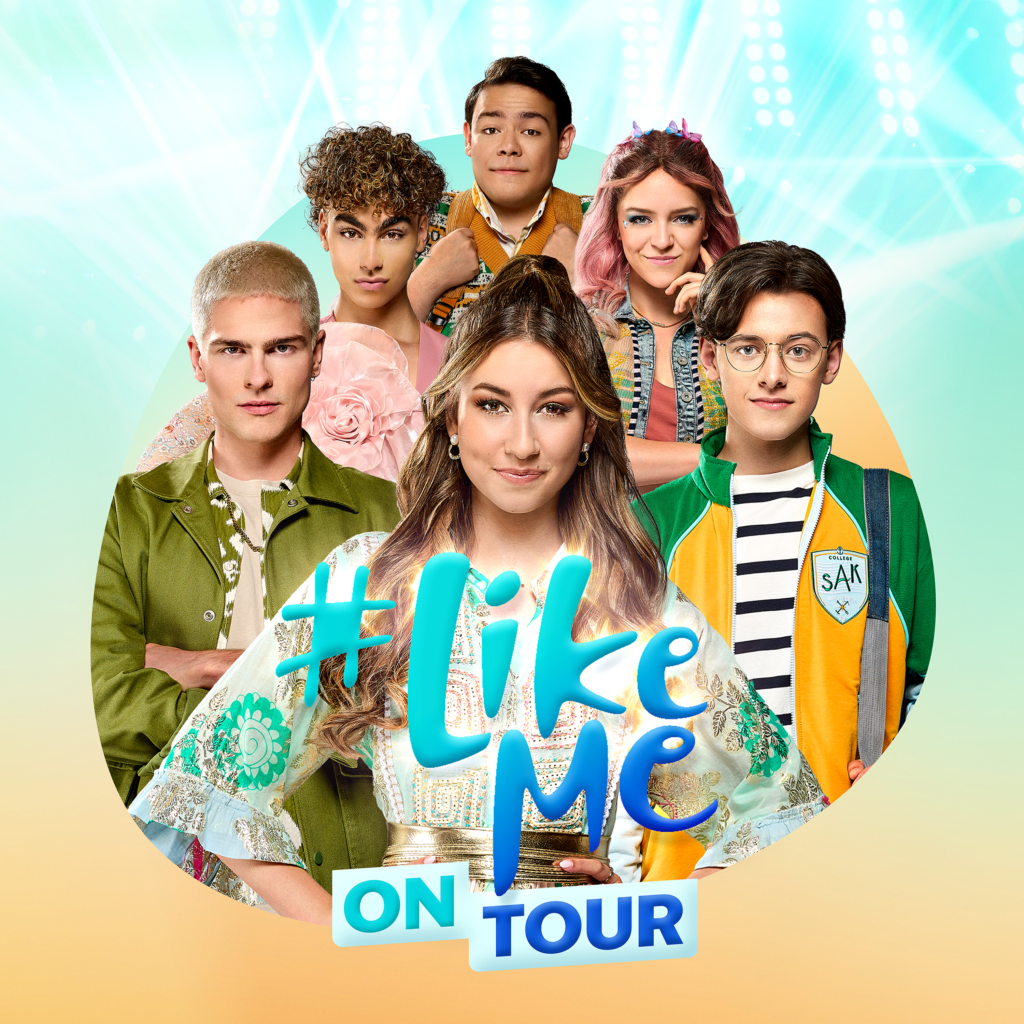 De cast van #LikeMe live op het podium, zingend en dansend voor een enthousiast publiek vol kinderen en ouders.