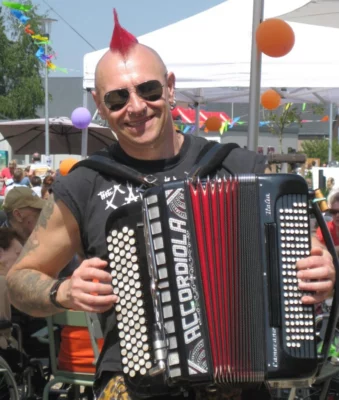Accordeonist Marino Punk treedt live op met zijn accordeon tijdens een sfeervol evenement.