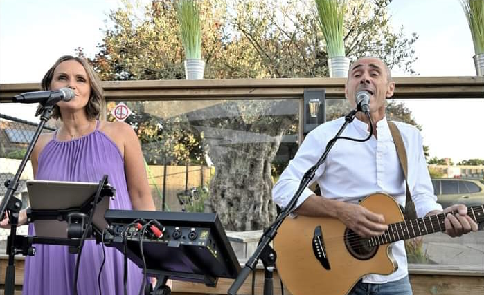 Live optreden van Totally Soul: Elisabeth zingt tussen het publiek, José begeleidt op gitaar.