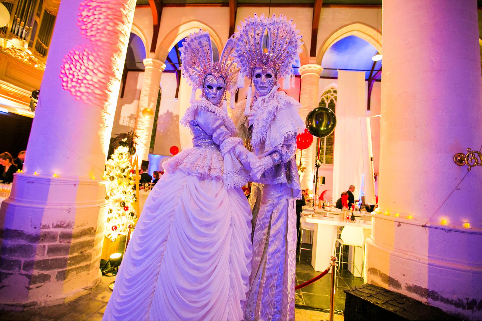 Festa Venezia, twee Venetiaanse steltenlopers in maagdelijk wit tussen de gasten, te boeken via Dream Animations.