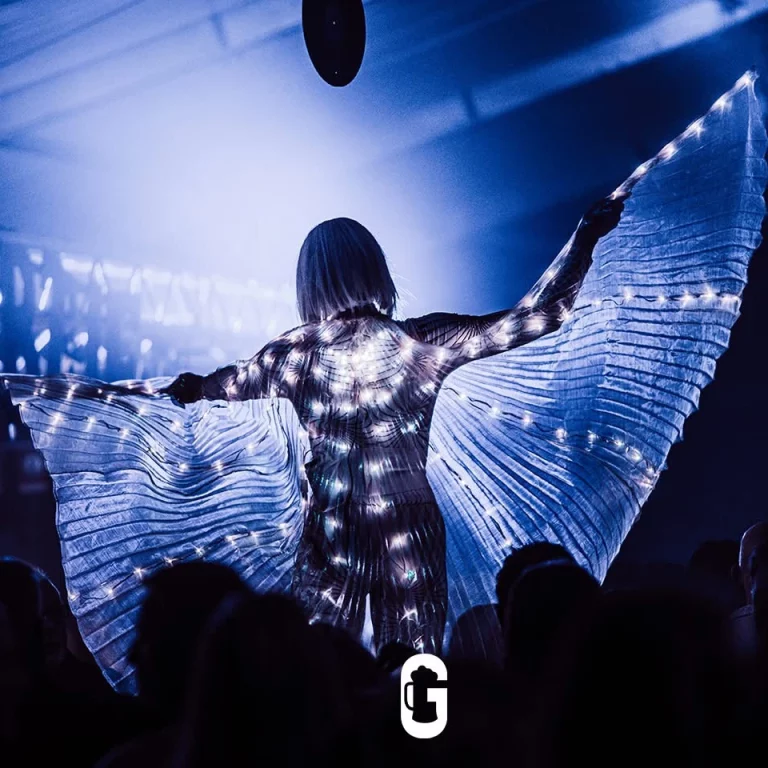 Twee kleurrijk verlichte LED Disco Steltenlopers met oplichtende maskers en vleugels, beschikbaar om te boeken bij Dream Animations voor je event.
