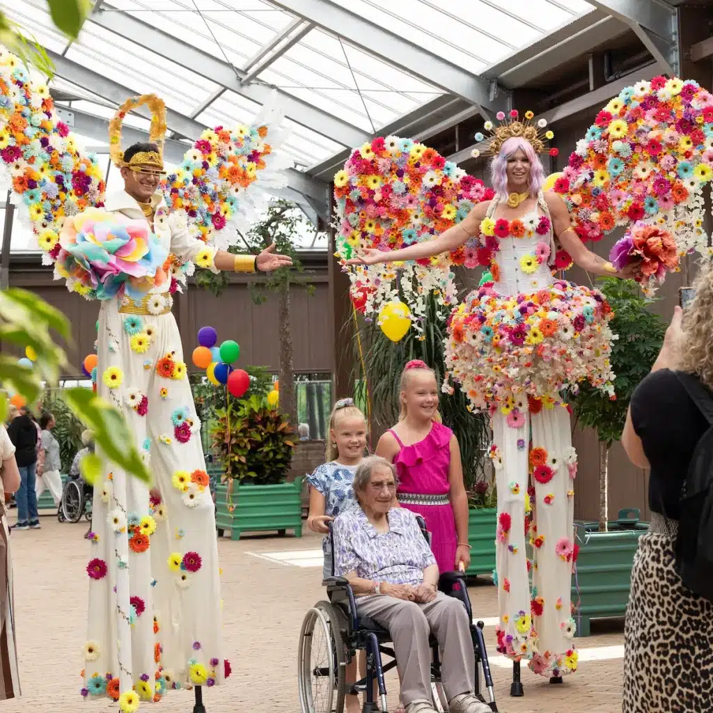 Bloemen steltenlopers in kleurrijke kostuums tijdens straatanimatie op festival of evenement
